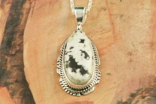 White Buffalo Turquoise set in Sterling Silver Pendant. This Beautiful Stone is formed from the minerals Calcite and Iron. It is mined near Tonopah Nevada. Free 18" Sterling Silver Chain with Purchase of Pendant. Created by Navajo Artist Larson Lee. Signed by the artist.